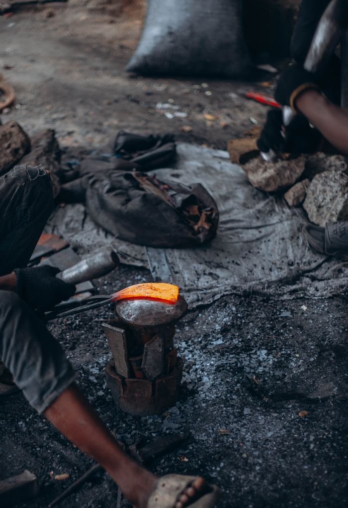 Services A blacksmith skillfully crafts hot iron using a hammer and anvil, showcasing traditional metalworking.