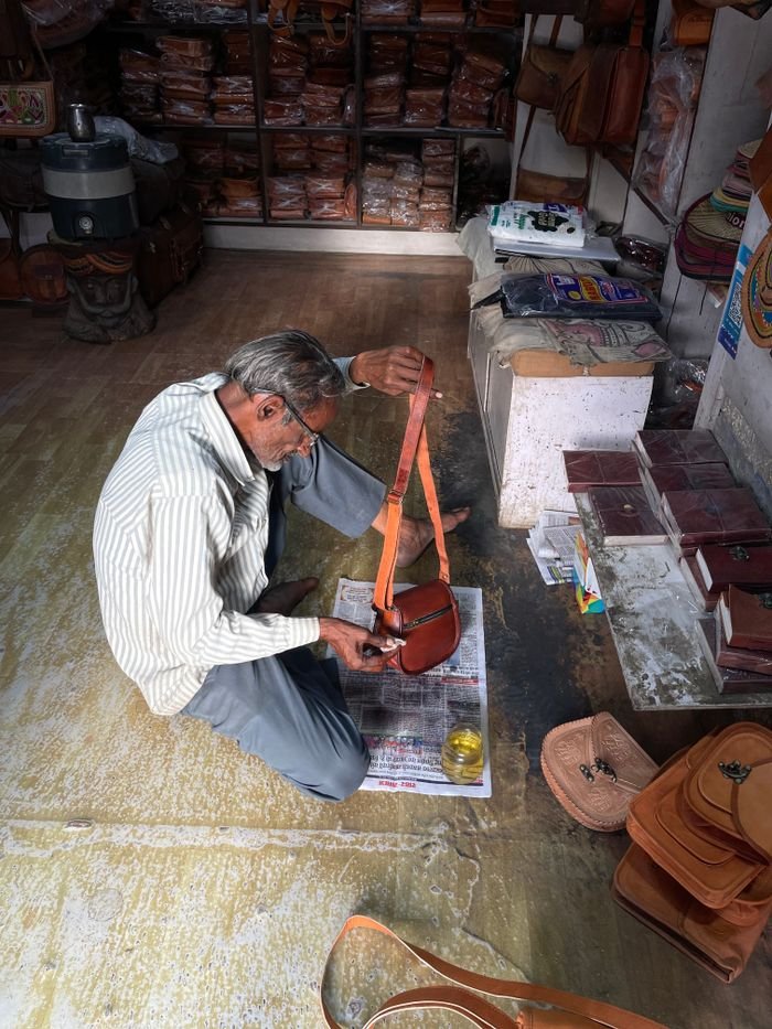 About Artisan crafting leather goods in a traditional Jaisalmer shop, India.